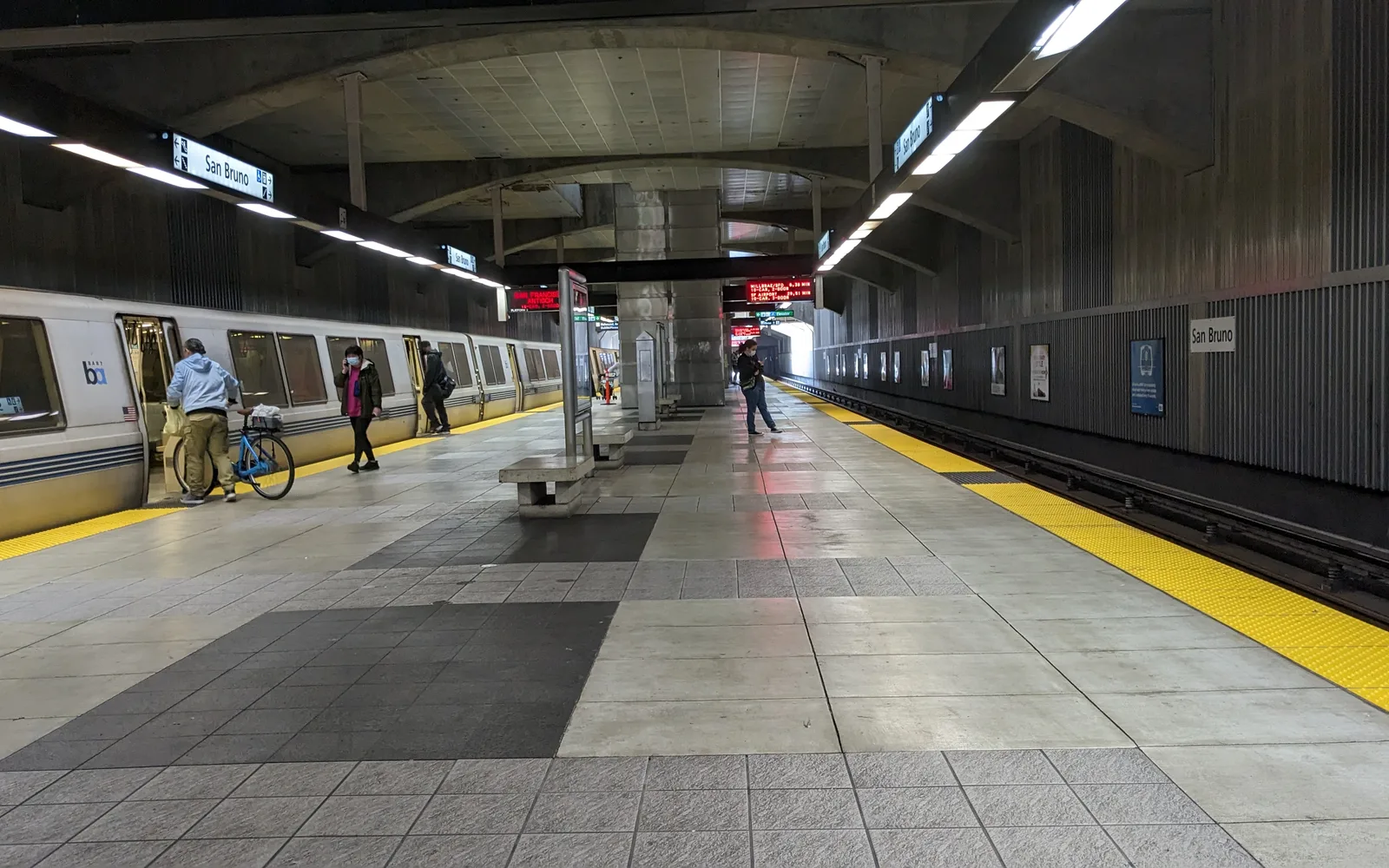 A BART train at the San Bruno station platform, showing modern transit infrastructure connecting the Peninsula to San Francisco Airport